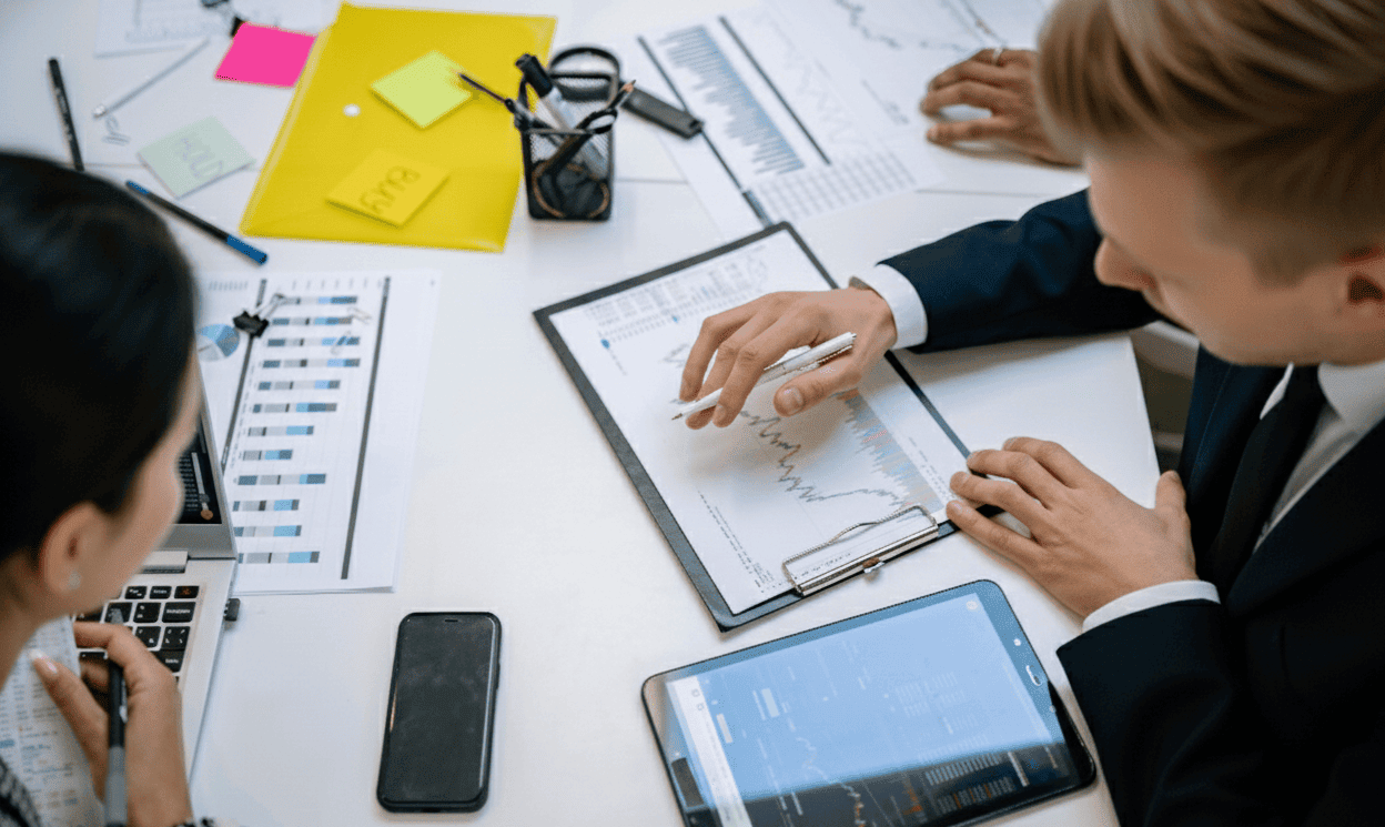 Un consultant et une autre personne sont assis à une table de travail ; ils sont très occupés.