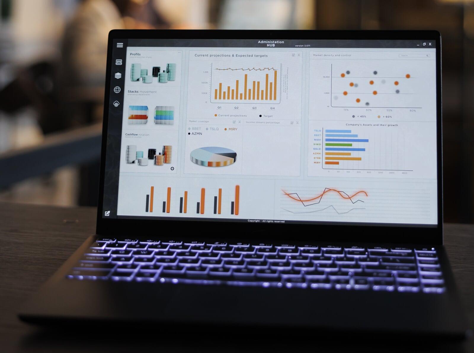 3 consultants, deux jeunes hommes et une jeune femme, sont assis autour d’une table, dans un openspace, et travaillent en équipe projet.